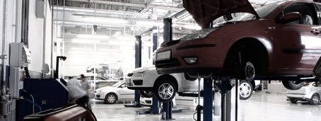 Werkstatt Werkstatt mit mehreren Fahrzeugen, einige auf Hebebühnen, andere in Reparatur.